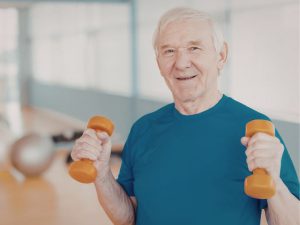 Älterer Mann mit kleinen Hanteln macht Krafttraining